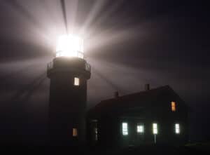 Seguin Island Lighthouse's first order Fresnel lens shining at night.